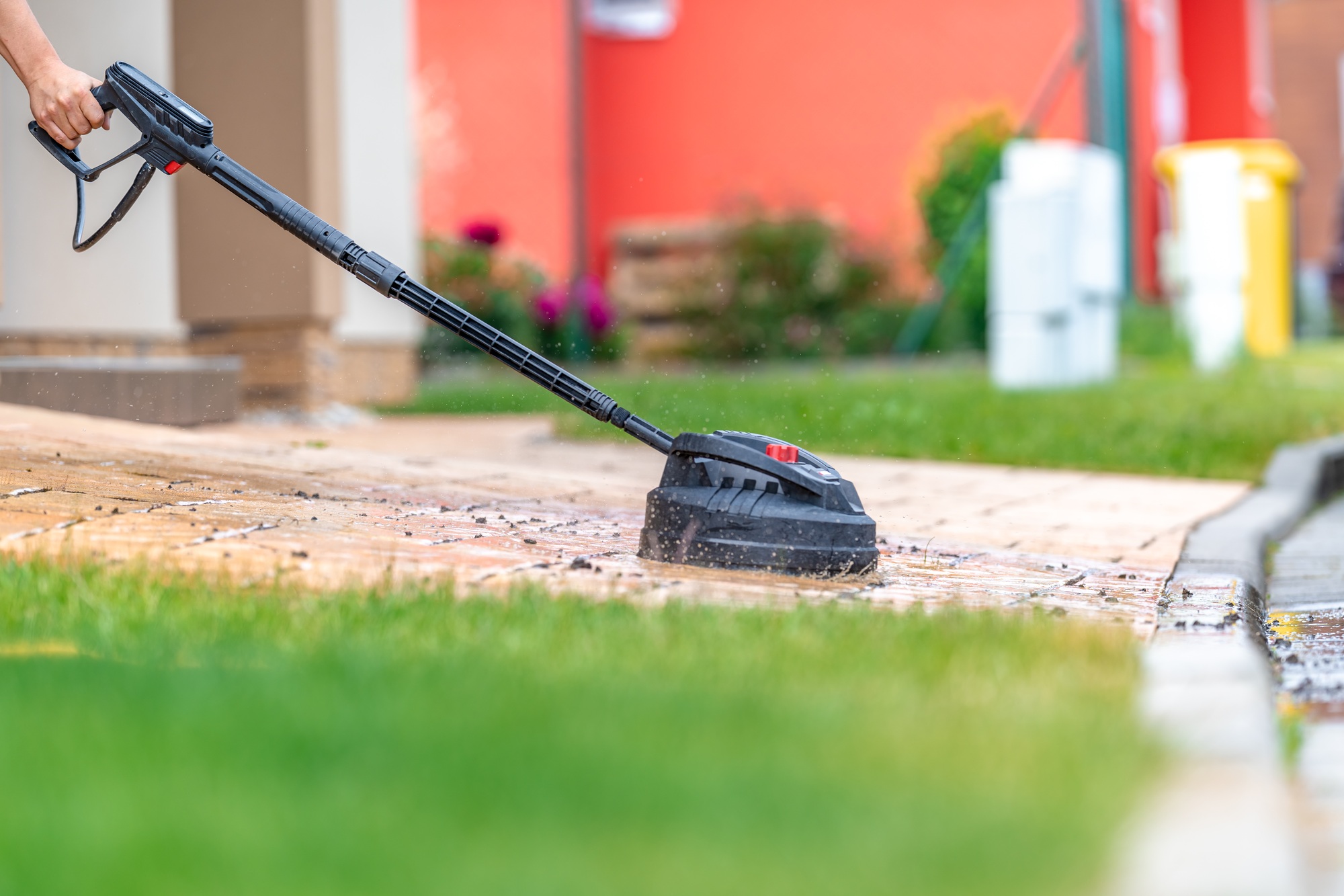 modern machine cleaning concrete pavement in front of the house with a brush